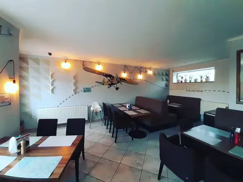 Sala Bistro na Żwirki: stoliki, ciepłe światło, jasne ściany
